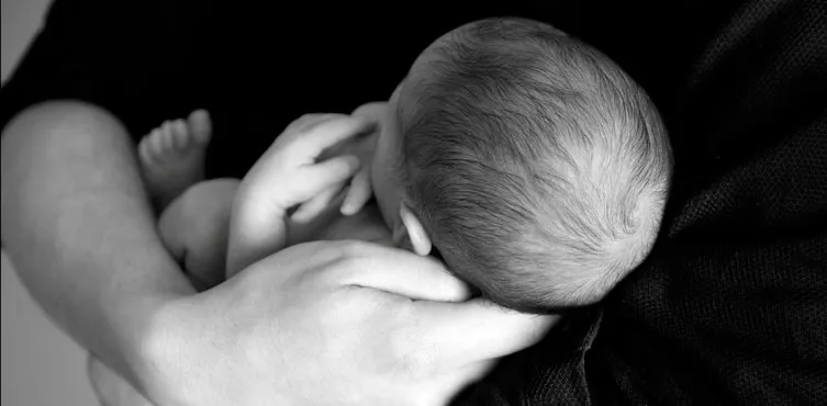 Mother Holding Baby While Supporting Neck And Head